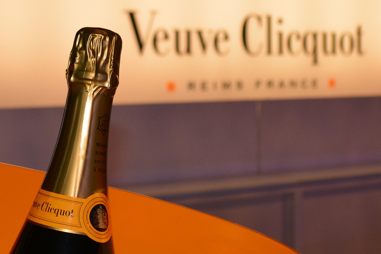 immagine di una bottiglia di Veuve Clicquot con in evidenza il logo in una vetrina nel background.